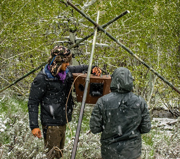 Lead author (left) setting up a speaker tripod for whitewater river noise playback.